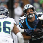 SEATTLE, WASHINGTON - SEPTEMBER 24: Devon Witherspoon #21 of the Seattle Seahawks hits Adam Thielen #19 of the Carolina Panthers as Thielen catches a touchdown during the fourth quarter at Lumen Field on September 24, 2023 in Seattle, Washington. (Photo by Steph Chambers/Getty Images)
