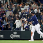 SEATTLE, WASHINGTON - SEPTEMBER 26: Mike Ford #20 of the Seattle Mariners reacts after as he scores on a Houston Astros throwing error during the third inning aat T-Mobile Park on September 26, 2023 in Seattle, Washington. (Photo by Steph Chambers/Getty Images)