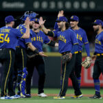 SEATTLE, WASHINGTON - SEPTEMBER 29: Dominic Leone #54, Cal Raleigh #29, Ty France #23, Eugenio Suarez #28, Josh Rojas #4 and Jose Caballero #76 of the Seattle Mariners celebrate their 8-0 win against the Texas Rangers at T-Mobile Park on September 29, 2023 in Seattle, Washington. (Photo by Steph Chambers/Getty Images)