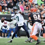 CINCINNATI, OHIO - OCTOBER 15: Geno Smith #7 of the Seattle Seahawks throws a pass while under pressure by Sam Hubbard #94 of the Cincinnati Bengals during the first half at Paycor Stadium on October 15, 2023 in Cincinnati, Ohio. (Photo by Michael Hickey/Getty Images)