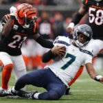 CINCINNATI, OHIO - OCTOBER 15: Geno Smith #7 of the Seattle Seahawks slides while under pressure by Mike Hilton #21 of the Cincinnati Bengals during the fourth quarter at Paycor Stadium on October 15, 2023 in Cincinnati, Ohio. (Photo by Dylan Buell/Getty Images)