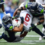 SEATTLE, WASHINGTON - OCTOBER 22: Bobby Wagner #54 and Jamal Adams #33 of the Seattle Seahawks tackle Joshua Dobbs #9 of the Arizona Cardinals in the first quarter of the game at Lumen Field on October 22, 2023 in Seattle, Washington. (Photo by Jane Gershovich/Getty Images)