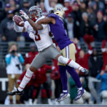 SEATTLE, WASHINGTON - NOVEMBER 25: Josh Kelly #3 of the Washington State Cougars catches a touchdown pass against Jabbar Muhammad #1 of the Washington Huskies during the first quarter at Husky Stadium on November 25, 2023 in Seattle, Washington. (Photo by Steph Chambers/Getty Images)