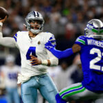 ARLINGTON, TEXAS - NOVEMBER 30:  Quarterback Dak Prescott #4 of the Dallas Cowboys looks to pass as cornerback Devon Witherspoon #21 of the Seattle Seahawks defends during the 1st quarter of the game at AT&T Stadium on November 30, 2023 in Arlington, Texas. (Photo by Ron Jenkins/Getty Images)