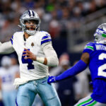 ARLINGTON, TEXAS - NOVEMBER 30:  Quarterback Dak Prescott #4 of the Dallas Cowboys looks to pass as cornerback Devon Witherspoon #21 of the Seattle Seahawks defends during the 1st quarter of the game at AT&T Stadium on November 30, 2023 in Arlington, Texas. (Photo by Ron Jenkins/Getty Images)