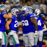 ARLINGTON, TEXAS - NOVEMBER 30:  Running back Zach Charbonnet #26 of the Seattle Seahawks is congratulated by teammates after scoring a touchdown during the 2nd quarter of the game against the Dallas Cowboys at AT&T Stadium on November 30, 2023 in Arlington, Texas. (Photo by Ron Jenkins/Getty Images)