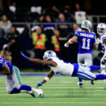ARLINGTON, TEXAS - NOVEMBER 30:  Wide receiver Tyler Lockett #16 of the Seattle Seahawks makes a catch for a first down as cornerback Jourdan Lewis #2 of the Dallas Cowboys defends during the 2nd quarter of the game at AT&T Stadium on November 30, 2023 in Arlington, Texas. (Photo by Ron Jenkins/Getty Images)