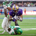LAS VEGAS, NEVADA - DECEMBER 01: Dillon Johnson #7 of the Washington Huskies dives over Jamal Hill #9 of the Oregon Ducks during the fourth quarter during the Pac-12 Championship at Allegiant Stadium on December 01, 2023 in Las Vegas, Nevada. (Photo by Ian Maule/Getty Images)