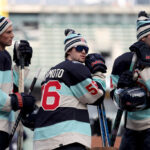 SEATTLE, WASHINGTON - DECEMBER 31: Brian Dumoulin #8, Kailer Yamamoto #56 and Justin Schultz #4 of the Seattle Kraken look on during practice before the Discover NHL Winter Classic at T-Mobile Park on December 31, 2023 in Seattle, Washington. (Photo by Steph Chambers/Getty Images)