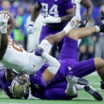 NEW ORLEANS, LOUISIANA - JANUARY 01: Ja'Tavion Sanders #0 of the Texas Longhorns is tackled by Alphonzo Tuputala #11 and Asa Turner #20 of the Washington Huskies after a catch during the second quarter during the CFP Semifinal Allstate Sugar Bowl at Caesars Superdome on January 01, 2024 in New Orleans, Louisiana. (Photo by Jonathan Bachman/Getty Images)