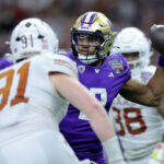 NEW ORLEANS, LOUISIANA - JANUARY 01: Michael Penix Jr. #9 of the Washington Huskies looks to pass against the rush of Ethan Burke #91 of the Texas Longhorns during the fourth quarter during the CFP Semifinal Allstate Sugar Bowl at Caesars Superdome on January 01, 2024 in New Orleans, Louisiana. (Photo by Jonathan Bachman/Getty Images)
