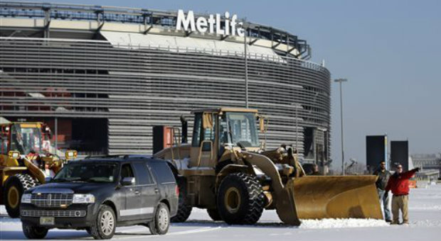 Workers prepare to remove snow from parking lots at MetLife stadium in East Rutherford, N.J., Wedne...