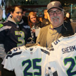 A shopper gathers up jerseys at the Seahawks Pro Shop at CenturyLink Field Monday.