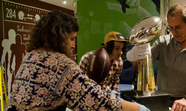 A crew prepares the Lombardi trophy for the opening of the new EMP Museum exhibition “We Are ...
