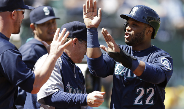 Seattle Mariners’ Robinson Cano is congratulated after scoring against the Oakland Athletics ...