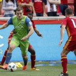               Seattle Sounders' Jordan Morris (13) looks to pass the ball as he is held by Real Salt Lake's Aaron Maund, back, during the first half of an MLS soccer game on Saturday, March 12, 2016, in Sandy, Utah. (AP Photo/Kim Raff)
            