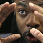 Seattle Seahawks cornerback Richard Sherman gestures as he answers a question during a panel discussion at Harvard University in Cambridge, Mass., Wednesday, April 23, 2014. Sherman told Harvard students that he refuses to back down from his rant after the NFC championship game because he wants to "educate the uneducated." (AP Photo/Charles Krupa)