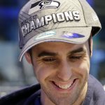 Phillip Kennedy grins after purchasing a Seattle Seahawks' Super Bowl championship cap for $35 at the team store, Monday, Feb. 3, 2014, in Seattle. The Seahawks defeated the Denver Broncos on Sunday in the Super Bowl XLVIII NFL football game, 43-8. (AP Photo/Elaine Thompson)