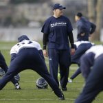 Seattle Seahawks defensive coordinator Dan Quinn, center, walks on the field as his players stretch before NFL football practice on Wednesday, Jan. 15, 2014, in Renton, Wash. (AP Photo/Ted S. Warren)