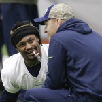 Seattle Seahawks running back Marshawn Lynch holds a candy cane in his mouth as he talks with offensive coordinator Darrell Bevell, right, before NFL football practice, Wednesday, Jan. 6, 2016, in Renton, Wash. Lynch has been recovering since having abdominal surgery last November. (AP Photo/Ted S. Warren)