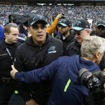 Carolina Panthers head coach Ron Rivera, center, is greeted by Seattle Seahawks head coach Pete Carroll, right, following an NFL football game, Sunday, Oct. 18, 2015, in Seattle. The Panthers beat the Seahawks 27-23. (AP Photo/Elaine Thompson)