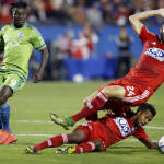 FC Dallas defender Matt Hedges (24) and midfielder Kellyn Acosta, bottom, collide while trying to break up a pass intended for Seattle Sounders FC forward Obafemi Martins (9) during the first half of an MLS soccer western conference semifinal playoff match Sunday, Nov. 8, 2015, in Frisco, Texas. (AP Photo/Brad Loper)