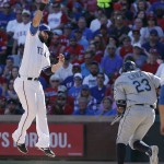 Texas Rangers first baseman Mitch Moreland, left, leaps to catch a throw from shortstop Elvis Andrus, allowing Seattle Mariners Nelson Cruz (23) to reach first during the sixth inning of a baseball game, Monday, April 4, 2016, in Arlington, Texas. Andrus was charged with a throwing error on the play. (AP Photo/Brandon Wade)