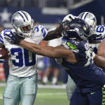 Dallas Cowboys' Christine Michael (30) fights off a tackle by Seattle Seahawks defensive end Michael Bennett (72) in the first half of an NFL football game, Sunday, Nov. 1, 2015, in Arlington, Texas. (AP Photo/Michael Ainsworth)
