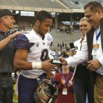 Washington fullback Myles Gaskin (9) accepts the MVP award from  Zaxby's Chief Operating Officer Robert Baxley, right, as Washington coach Chris Petersen watches after Washington's 44-31 victory over Southern Mississippi in the Heart of Dallas Bowl NCAA college football game, Saturday, Dec. 26, 2015, in Dallas. (AP Photo/Ron Jenkins)
