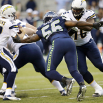 Seattle Seahawks defensive end Cliff Avril (56) gets a hand on San Diego Chargers quarterback Kellen Clemens (10) as Avril is blocked by Chargers offensive tackle D.J. Fluker, right, in the first half of a preseason NFL football game, Friday, Aug. 15, 2014, in Seattle. (AP Photo/Stephen Brashear)