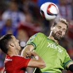Seattle Sounders FC defender Chad Marshall, center, goes up for a header against FC Dallas defender Matt Hedges, left, during the first half of an MLS soccer western conference semifinal playoff match Sunday, Nov. 8, 2015, in Frisco, Texas. FC Dallas defender/midfielder Je-Vaughn Watson (27) is at right. (AP Photo/Brad Loper)