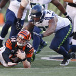 Cincinnati Bengals quarterback Andy Dalton (14) dives for extra yards on a run against Seattle Seahawks defensive end Michael Bennett (72) in overtime of an NFL football game, Sunday, Oct. 11, 2015, in Cincinnati. (AP Photo/Gary Landers)