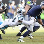 Carolina Panthers cornerback Josh Norman (24) tackles Seattle Seahawks quarterback Russell Wilson (3) during the second half of an NFL divisional playoff football game, Sunday, Jan. 17, 2016, in Charlotte, N.C. (AP Photo/Mike McCarn)