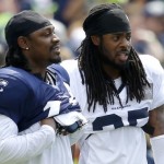 Seattle Seahawks running back Marshawn Lynch, left, stands with cornerback Richard Sherman as they watch drills Saturday, Aug. 2, 2014, during NFL football training camp in Renton, Wash. (AP Photo/Ted S. Warren)