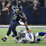 Seattle Seahawks' Russell Wilson (3) breaks away from a tackle-attempt by Dallas Cowboys' Rolando McClain (55) in the second half of an NFL football game Sunday, Nov. 1, 2015, in Arlington, Texas. (AP Photo/Michael Ainsworth)