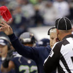 Seattle Seahawks head coach Pete Carroll tosses the challenge flag as he talks to line judge Tom Stephan (68) to challenge a call during an NFL football game against the Carolina Panthers, Sunday, Oct. 18, 2015, in Seattle. (AP Photo/Elaine Thompson)