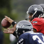 Seattle Seahawks quarterback Russell Wilson takes a snap at an NFL football training camp Monday, Aug. 3, 2015, in Renton, Wash. (AP Photo/Elaine Thompson)