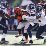 Cincinnati Bengals running back Giovani Bernard (25) is tackled by Seattle Seahawks free safety Earl Thomas (29) and strong safety DeShawn Shead (35) in the second half of an NFL football game, Sunday, Oct. 11, 2015, in Cincinnati. (AP Photo/Gary Landers)