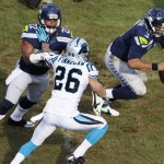 Seattle Seahawks quarterback Russell Wilson (3) runs by Carolina Panthers defensive back Cortland Finnegan (26) during the second half of an NFL divisional playoff football game, Sunday, Jan. 17, 2016, in Charlotte, N.C. (AP Photo/Bob Leverone)