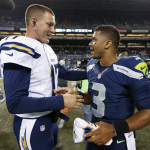 Seattle Seahawks quarterback Russell Wilson (3) visits with San Diego Chargers quarterback Philip Rivers after the Seahawks defeated the Chargers 41-14 in a preseason NFL football game, Friday, Aug. 15, 2014, in Seattle. (AP Photo/John Froschauer)