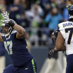 Seattle Seahawks defensive tackle Jordan Hill, left, celebrates after he intercepted a pass in the second half of an NFL football game against the St. Louis Rams, Sunday, Dec. 28, 2014, in Seattle. (AP Photo/Scott Eklund)
