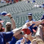 Texas Rangers Josh Hamilton, left, autographs a baseball for a young fan before a opening day baseball game against the Seattle Mariners, Monday, April 4, 2016, in Arlington, Texas. (AP Photo/Brandon Wade)