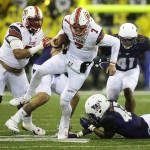 Utah quarterback Travis Wilson (7) eludes a tackle attempt by Washington linebacker Cory Littleton, lower right, on a keeper play during the first half of an NCAA college football game, Saturday, Nov. 7, 2015, in Seattle. (AP Photo/Ted S. Warren)