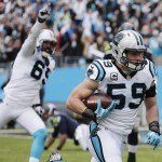 Carolina Panthers middle linebacker Luke Kuechly (59) runs an intercepted ball as Seattle Seahawks center Patrick Lewis (65) looks on during the first half of an NFL divisional playoff football game, Sunday, Jan. 17, 2016, in Charlotte, N.C. Kuechly scored a touchdown on the play. (AP Photo/Chuck Burton)