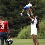 Seattle Seahawks quarterback Russell Wilson (3) looks on as his girlfriend, entertainer Ciara Harris, playfully tosses her son, Future, 14 months, in the air after an NFL football training camp Monday, Aug. 3, 2015, in Renton, Wash. (AP Photo/Elaine Thompson)