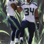 Seattle Seahawks running back Thomas Rawls (34) celebrates his touchdown with wide receiver Tyler Lockett, left, in the second half of an NFL football game against the Cincinnati Bengals, Sunday, Oct. 11, 2015, in Cincinnati. (AP Photo/Gary Landers)
