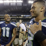 Seattle Seahawks' Percy Harvin (11) and Russell Wilson smile after the team defeated the Green Bay Packers 36-16 in an NFL football game, Thursday, Sept. 4, 2014, in Seattle. (AP Photo/Elaine Thompson)