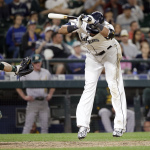 Seattle Mariners' Nelson Cruz, right, leaps back after being hit by a pitch as Oakland Athletics catcher Josh Phegley waits for the ball in the eighth inning of a baseball game Saturday, May 9, 2015, in Seattle. (AP Photo/Elaine Thompson)
