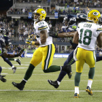 Green Bay Packers wide receiver Randall Cobb, right, comes down with a reception for a touchdown against the Seattle Seahawks in the second half of an NFL football game, Thursday, Sept. 4, 2014, in Seattle. (AP Photo/Elaine Thompson)