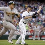 Seattle Mariners starting pitcher J.A. Happ, right, throws to first after fielding a grounder from Oakland Athletics' Josh Phegley (19) during the second inning of a baseball game Saturday, May 9, 2015, in Seattle. Phegley was safe at first on a throwing error by Happ. (AP Photo/Elaine Thompson)